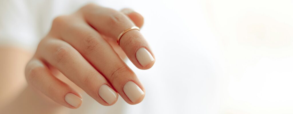 persons hand with white manicure